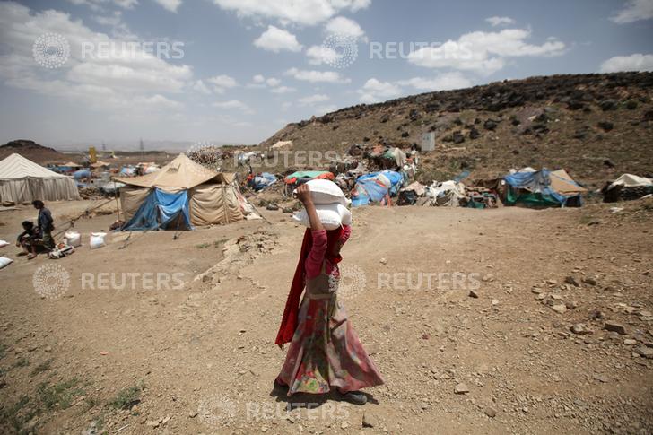 A girl carries food aid she received from the local charity, Mona Relief, ahead of the holy month of Ramadan on the outskirts of Sanaa, Yemen May 5, 2019. REUTERS/Khaled Abdullah