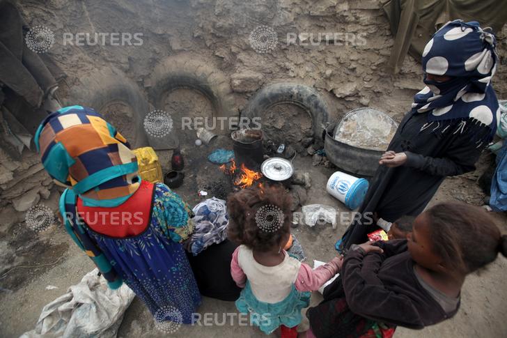 Women cook a meal after they received food aid from the local charity, Mona Relief, ahead of the holy month of Ramadan in a slum on the outskirts of Sanaa, Yemen May 5, 2019. REUTERS/Khaled Abdullah