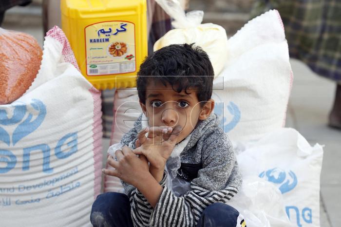 epa08002326 A conflict affected Yemeni child sits next to his family's food rations provided by Mona Relief Yemen in Sanaa, Yemen, 16 November 2019. According to reports, the ongoing conflict in Yemen since 2015 has created the worst humanitarian crisis in the world, with 10 million people living with extreme hunger and two million children under five already acutely malnourished, as the Arab country enters its fifth year of armed conflict between the Saudi-backed Yemeni government forces and the Houthi rebels.  EPA-EFE/YAHYA ARHAB
